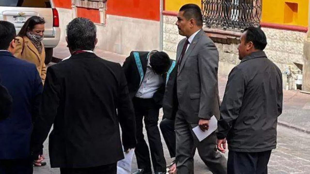 A sus pies, colaboradores limpian zapatos a Hugo Aguilar